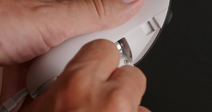 Hands can't extract battery from wireless joystick for VR headset.