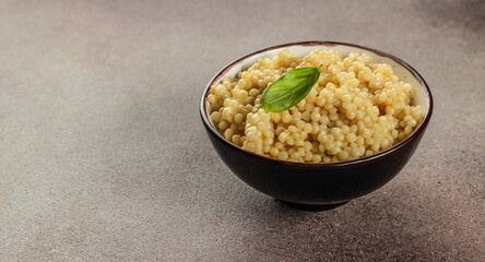 Boiled Ptitim Israeli pasta on a light background top view. copy space