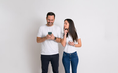 Curious woman peeking into boyfriend's phone and trying to check his messages on white background