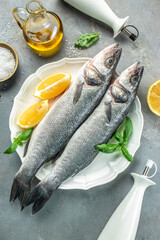 Fresh raw seabass and ingredients for cooking. banner, menu, recipe copy space, top view