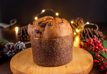 Traditional Italian panettone with chocolate for Christmas on wooden table.