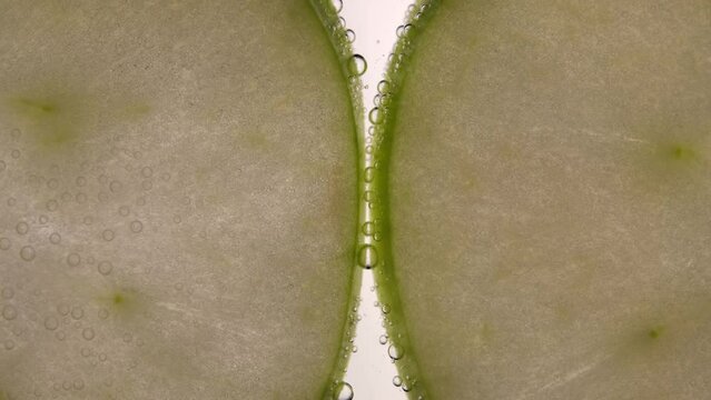 Close-up of green apple on top of fizzy soda
