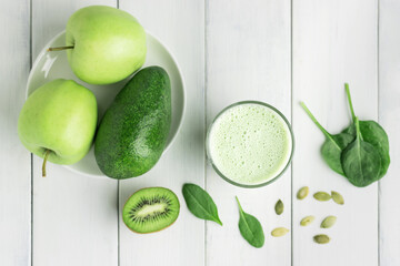 Green detox smoothie, blended vegetarian drink in a glass from spinach, apple, kiwi, avocado and...