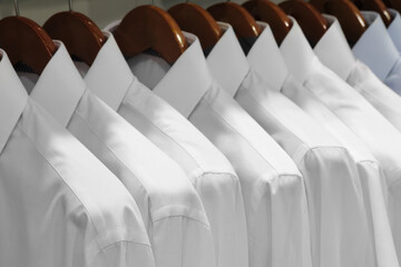 Closeup photo of Men's shirts hanging. Clothes hang on a shelf . Cloth Hangers with Shirts. Men's...