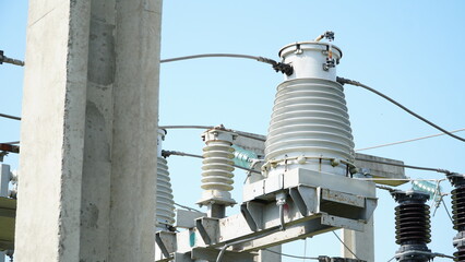 High and low voltage transformer bushings with electrical insulation and electrical equipment at a power substation. electrical equipment at the substation