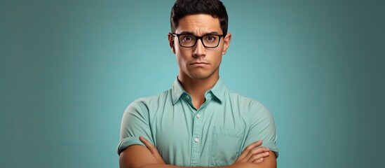 Young hispanic man wearing casual clothes and glasses skeptic and nervous disapproving expression on face with crossed arms negative person. Copyspace image. Header for website template - obrazy, fototapety, plakaty