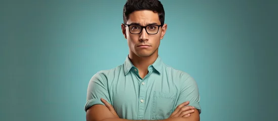 Foto op Canvas Young hispanic man wearing casual clothes and glasses skeptic and nervous disapproving expression on face with crossed arms negative person. Copyspace image. Header for website template © vxnaghiyev