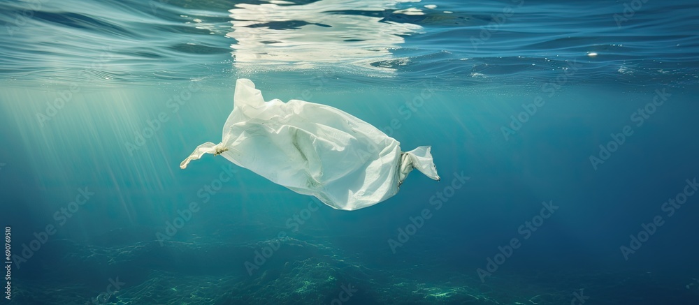 Aufkleber underwater pollution a discarded plastic carrier bag drifting in a tropical blue water ocean. copysp
