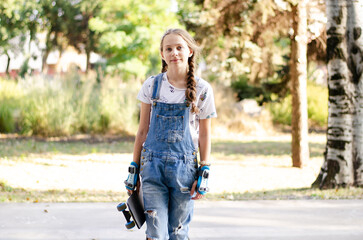 a girl with a skate in her hands and a denim overall