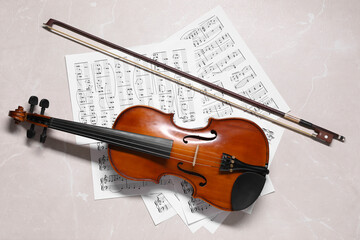 Violin, bow and music sheets on grey marble table, top view