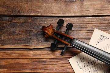 Violin and music sheets on wooden table, top view. Space for text