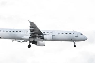 A passenger plane about to land with the landing gear deployed and flaps folded