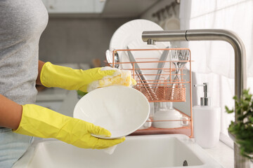 Woman washing bowl at sink in kitchen, closeup