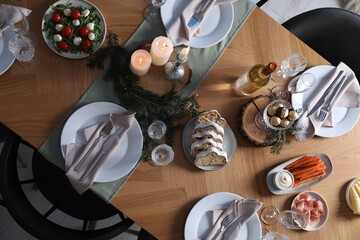 Christmas table setting with festive decor and dishware, top view