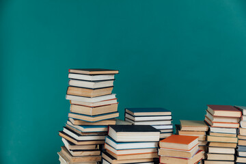 Stacks of books in university library on green background