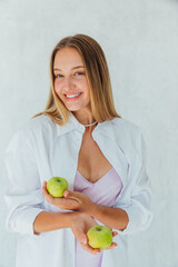 Beautiful woman holding two green apples in her hands