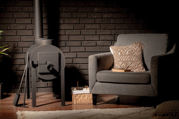 metal stove and chair on the background of a black brick wall