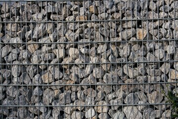 gray stones in a metal gabion fence background