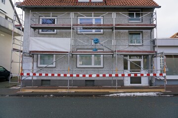 Facade scaffolding that stands on a garman house in need of renovation to work on