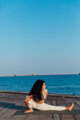 Fototapeta na wymiar Woman doing yoga asana breathing practice on the beach by the sea