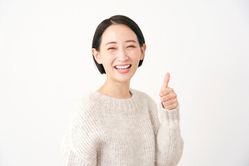 グッドサインする中年女性　白背景