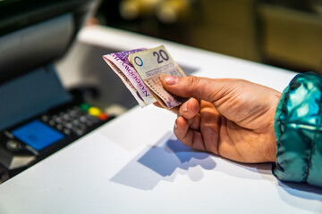 Woman paying in Polish zloty pln for a meal next to cash register inflation concept Polski ład - obrazy, fototapety, plakaty