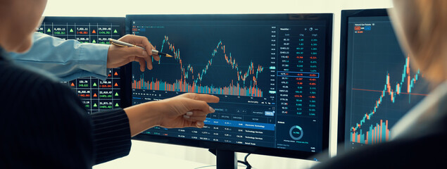 Group of skilled investor discuss about stock investment. Businesspeople look at stock charts...