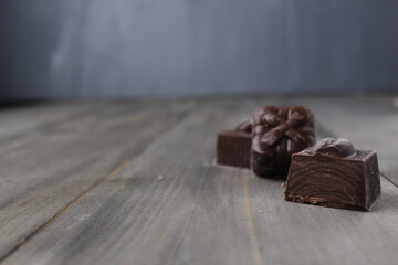 Cutaway chocolate candy with dark chocolate nut filling on grey background with space for copy space text