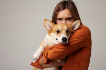 portrait of a girl and a corgi dog on a clean white background, love for animals - obrazy, fototapety, plakaty