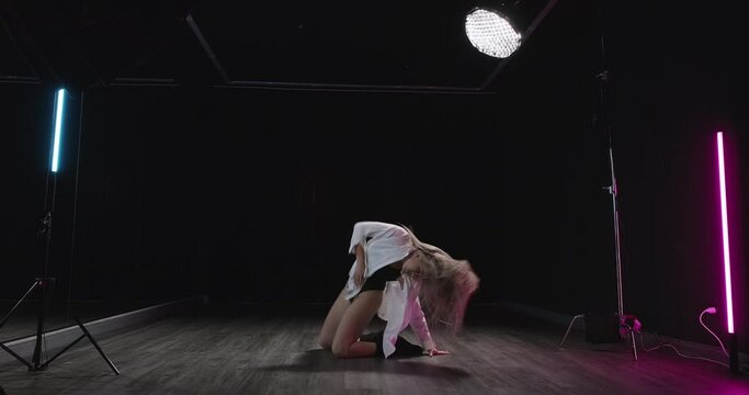 Sexy woman dancing sensually in dance studio. Young blonde dancer moving erotically, making sexy movements