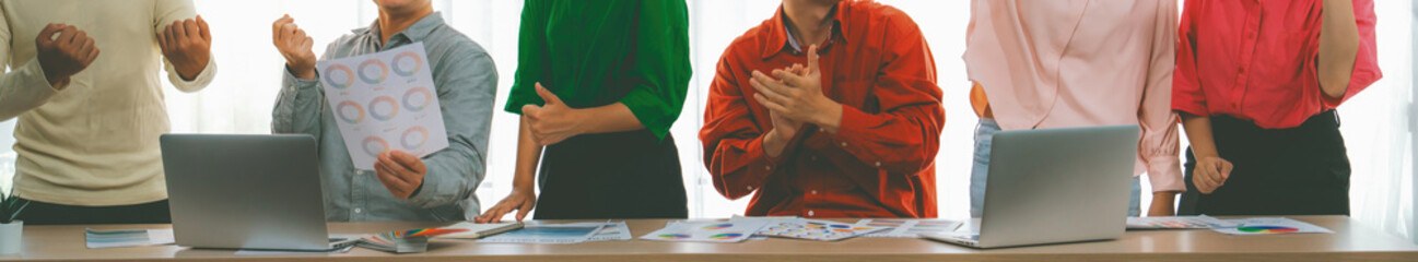 Cropped image of happy creative business group celebrate their success at meeting table with...