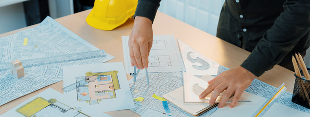 A portrait of architect using divider to measure blueprint. Architect designing house construction...