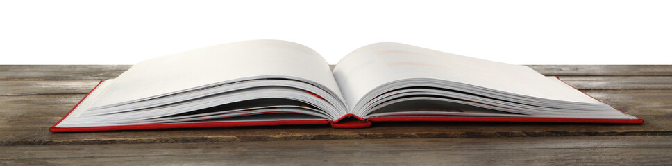 Open book with red cover on wooden table against white background