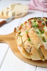 Freshly baked bread with tofu cheese and green onions on white wooden table, closeup