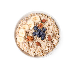 Tasty boiled oatmeal with banana, blueberries and nuts in bowl isolated on white, top view