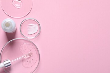 Bottle of cosmetic serum and petri dishes with samples on pink background, flat lay. Space for text
