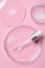 Pipette, cosmetic serum and petri dishes with samples on pink background, flat lay