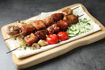 Delicious shish kebabs with vegetables and lavash on grey table