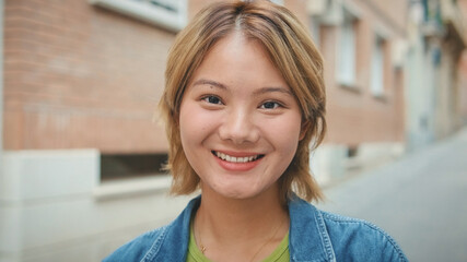 Close-up of young smiling woman looking at the camera