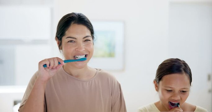 Happy mother, kid and brushing teeth in bathroom for dental care, hygiene or morning routine together at home. Mom and little girl or child smile for cleaning oral, gum or mouth in tooth whitening