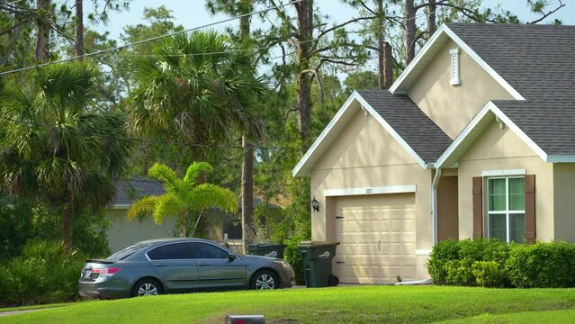 Single family home with double car garage door and wide driveway in front. Generic private house in southern Florida