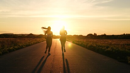 two friends running sunset, team group girls running sunset, silhouette athletic girls, teamwork asian female runner jogging road, jogging on top at sunset, legs athletes sports shoes, successful