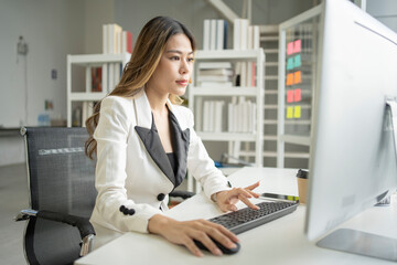 A determined young woman strategizing in the office, dedicated to propelling business growth with unwavering focus.