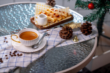 Cup of hot coffee and bakery goods Various waffles and breads are on the table. and decorated with Christmas There is a Christmas tree and various decorations. to celebrate the Christmas festival.