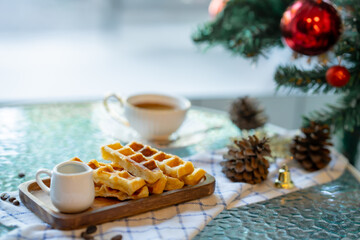 Cup of hot coffee and bakery goods Various waffles and breads are on the table. and decorated with Christmas There is a Christmas tree and various decorations. to celebrate the Christmas festival.
