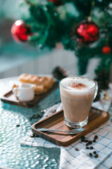 Cup of hot coffee and bakery goods Various waffles and breads are on the table. and decorated with Christmas There is a Christmas tree and various decorations. to celebrate the Christmas festival.