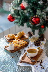 Cup of hot coffee and bakery goods Various waffles and breads are on the table. and decorated with Christmas There is a Christmas tree and various decorations. to celebrate the Christmas festival.