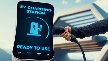 Businessman pull and hold EV charger plug form electric car charging station on sunny modern...