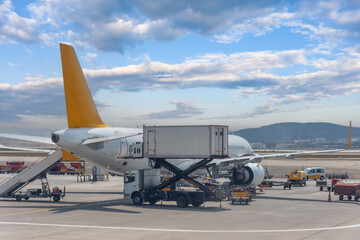 Trucks with a lift providing in-flight catering for a passenger airliner jet. - obrazy, fototapety, plakaty