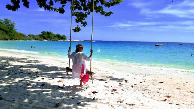 Asian Thai women on a beach with a swing at Koh Samet Island, Tropical Island Koh Samed Thailand on a sunny day in Thailand